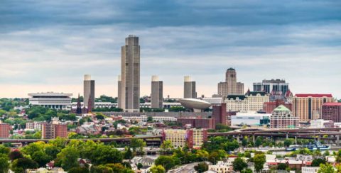 City skyline with tall buildings under a cloudy sky.