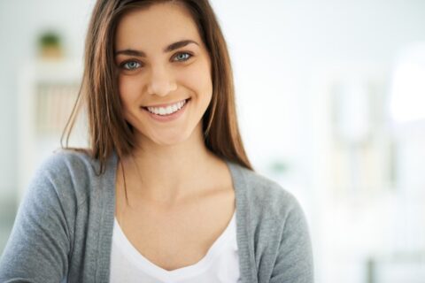 Smiling woman in a gray sweater.